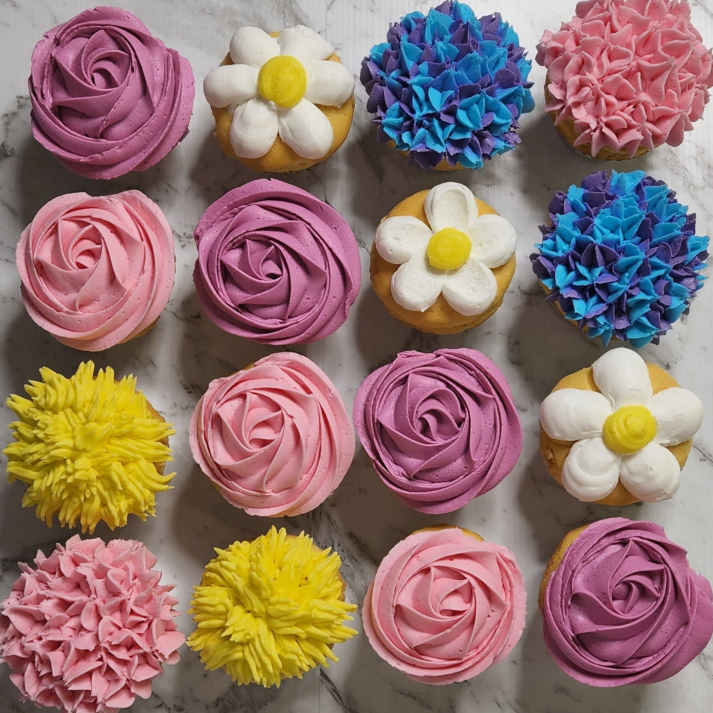 Assorted colorful cupcakes on a marble surface